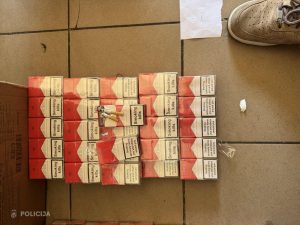 Valsts policijas konfiscētas "Smoking kills" cigaretes, kas sakrautas rindās uz flīžu grīdas.