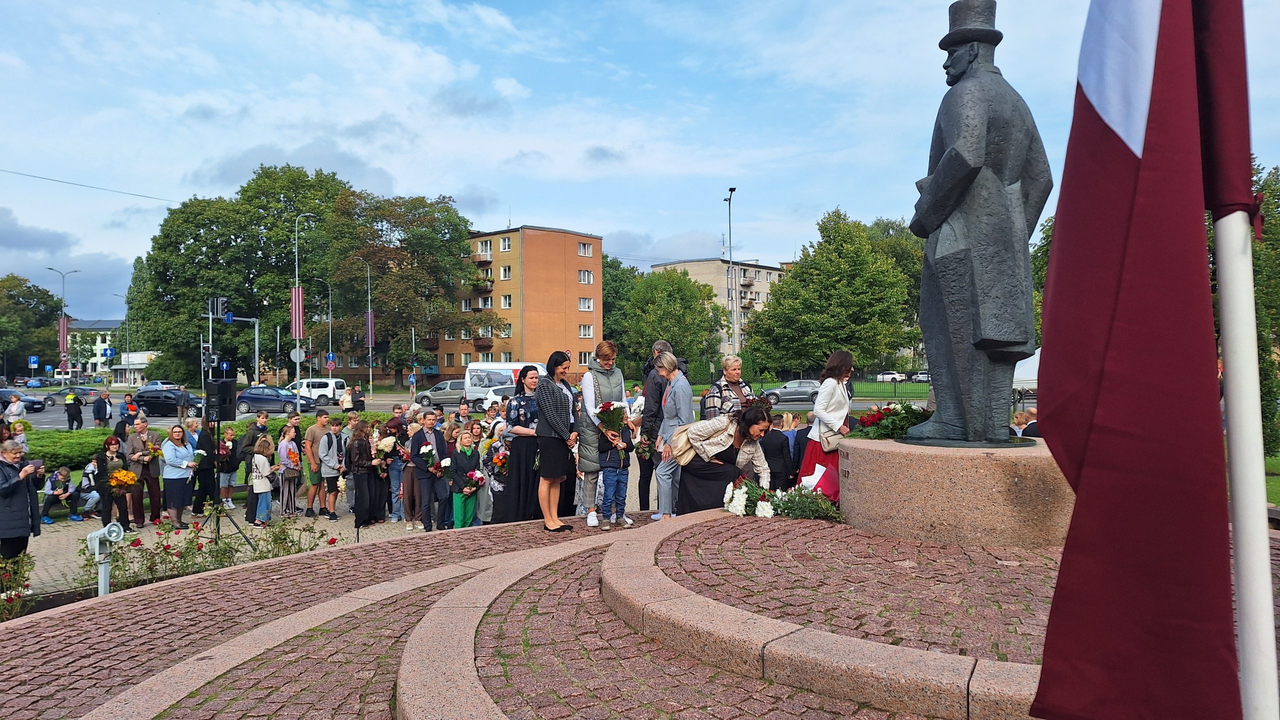 Cilvēki noliek ziedus pie Jāņa Čakstes pieminekļa.