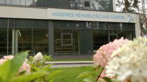 Vidzemes Rehabilitācijas centra ēka ar ziediem priekšplānā