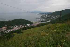 Skats uz piejūras pilsētu un ostu ar kalniem fonā