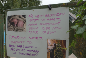 Plakāts Jēkabpilī ar nošautā suņa fotogrāfijām un emocionālu vēstījumu Klusās akcijas laikā.