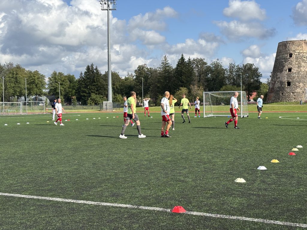 Grupa soļbola spēlētāju treniņa laikā uz futbola laukuma.