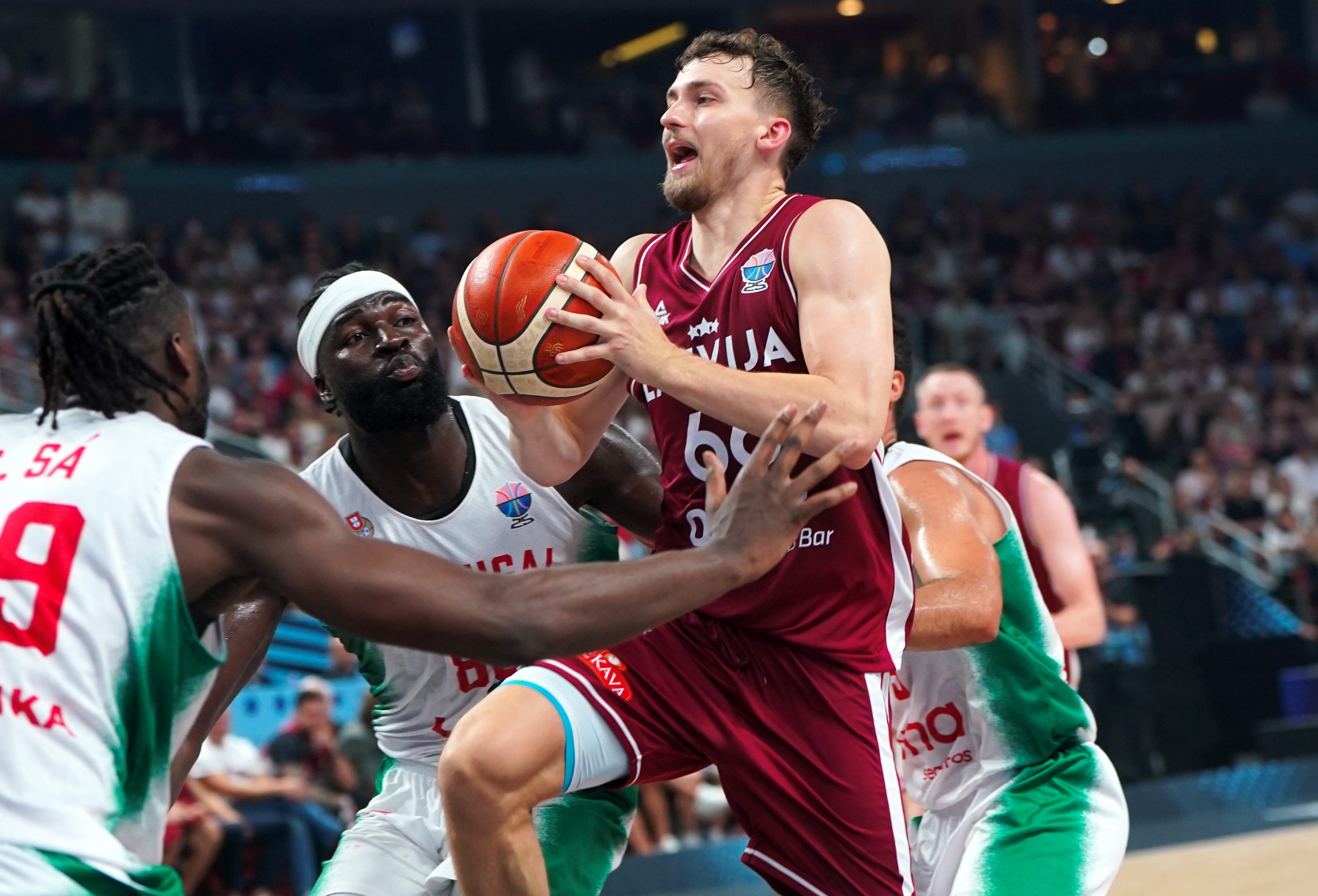 Latvijas basketbola izlases spēlētājs uzbrukumā pret Portugāles izlases aizsardzību Eiropas čempionāta spēlē Rīgā.