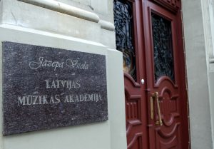 Jāzepa Vītola Latvijas Mūzikas akadēmijas ieeja ar nosaukuma plāksni pie sienas.