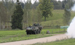 Militārais bruņutransportieris lauka mācībās pie meža