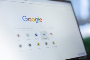 Tuvplāna attēls ar "Google" meklētājprogrammas sākumlapu datora ekrānā.