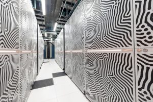 Skats uz JUPITER superdatora statīviem, kas pārklāti ar metāla paneļiem ar viļņotiem rakstiem.