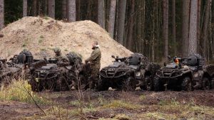 Karavīri ar sešriteņu visurgājējiem meža teritorijā militāro mācību laikā