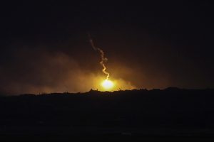 Nakts trieciens Gazas joslā: spožs sprādziens virs tumša silueta.
