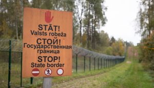 Zīme pie Latvijas valsts robežas ar uzrakstu "Stāt! Valsts robeža"