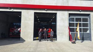 Ugunsdzēsēji pie jaunā depo ēkas ar Latvijas karogu