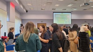 Cilvēki sarunājas vakanču gadatirgū Jelgavā konferenču zālē.