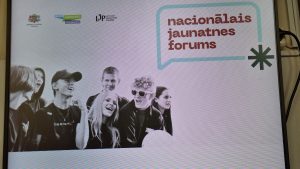 Ekrānā redzams Nacionālā jaunatnes foruma logo ar jauniešu attēlu un organizatoru simboliem.
