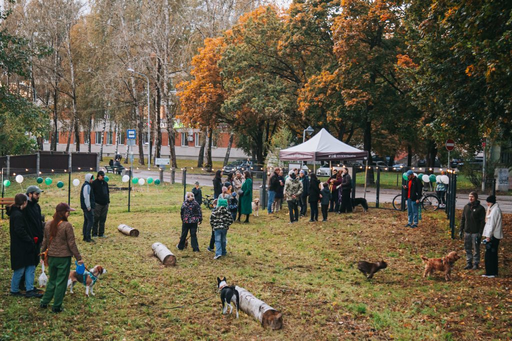 Plaša rudens aina ar cilvēkiem un suņiem jaunajā, iežogotajā suņu laukumā Čiekurkalnā.