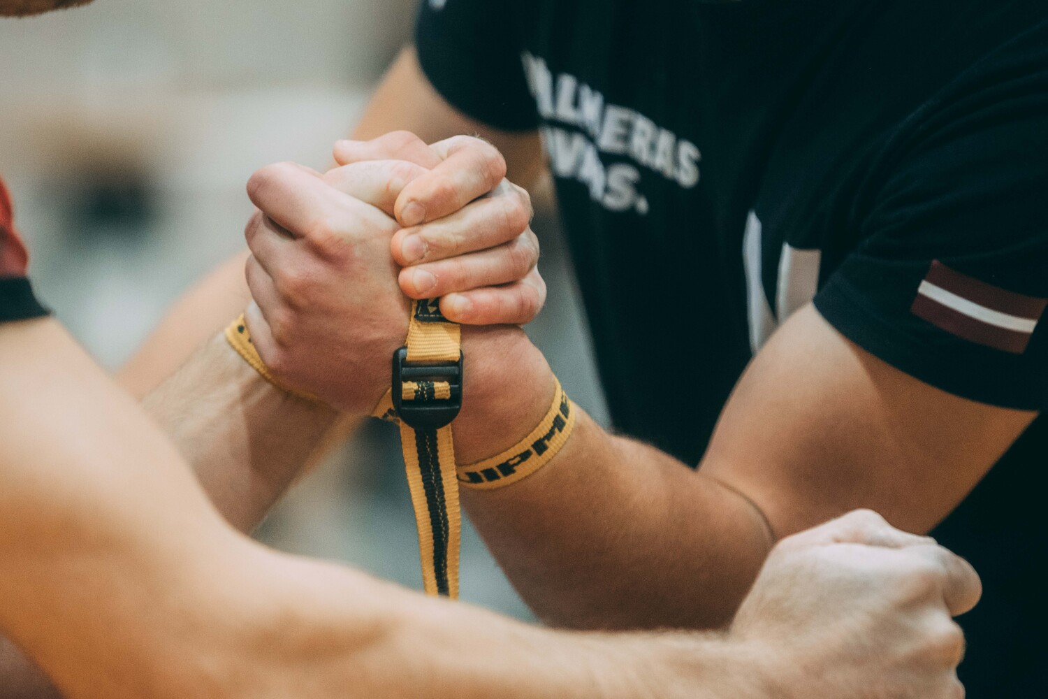 Valmieras labdarības kauss armvrestlingā: divu sportistu roku satveršanās Viestura vidusskolā, 25. oktobrī 2025.