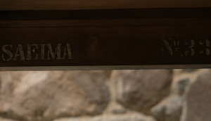 Uzraksts “SAEIMA” uz veca koka priekšmeta ar numuru