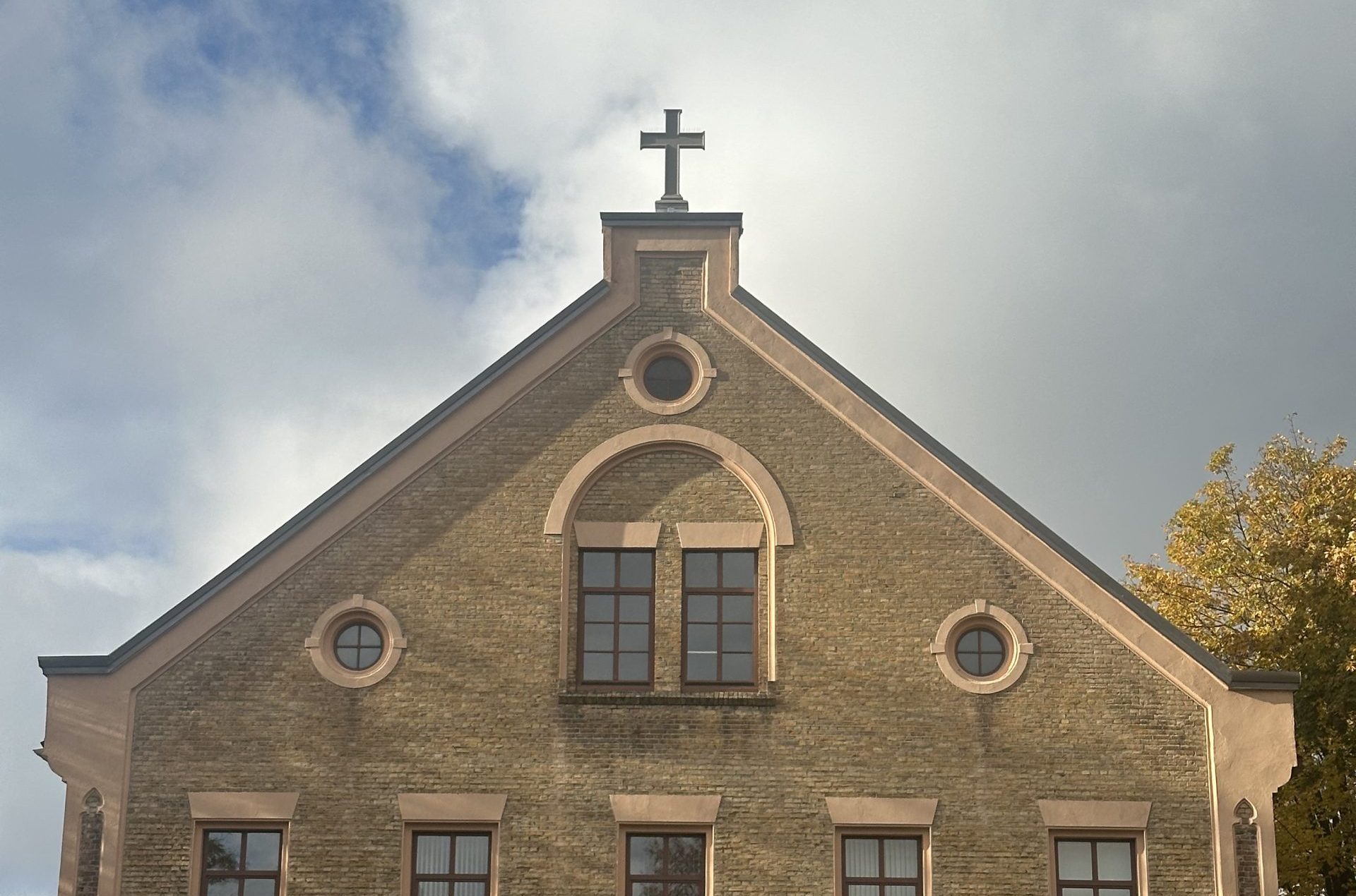 Ventspils baptistu baznīcas fasāde no priekšpuses, ar jaunu, uzstādītu krustu jumta kores augšgalā.