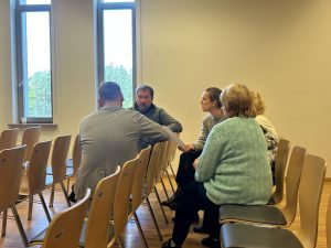 Cilvēki nelielā grupā diskutē Ogres novada NVO forumā.