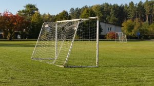 Futbola laukums ar vārtiem saulainā rudens dienā.