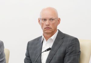 Gatis Truksnis sēž pie mikrofona preses konferencē