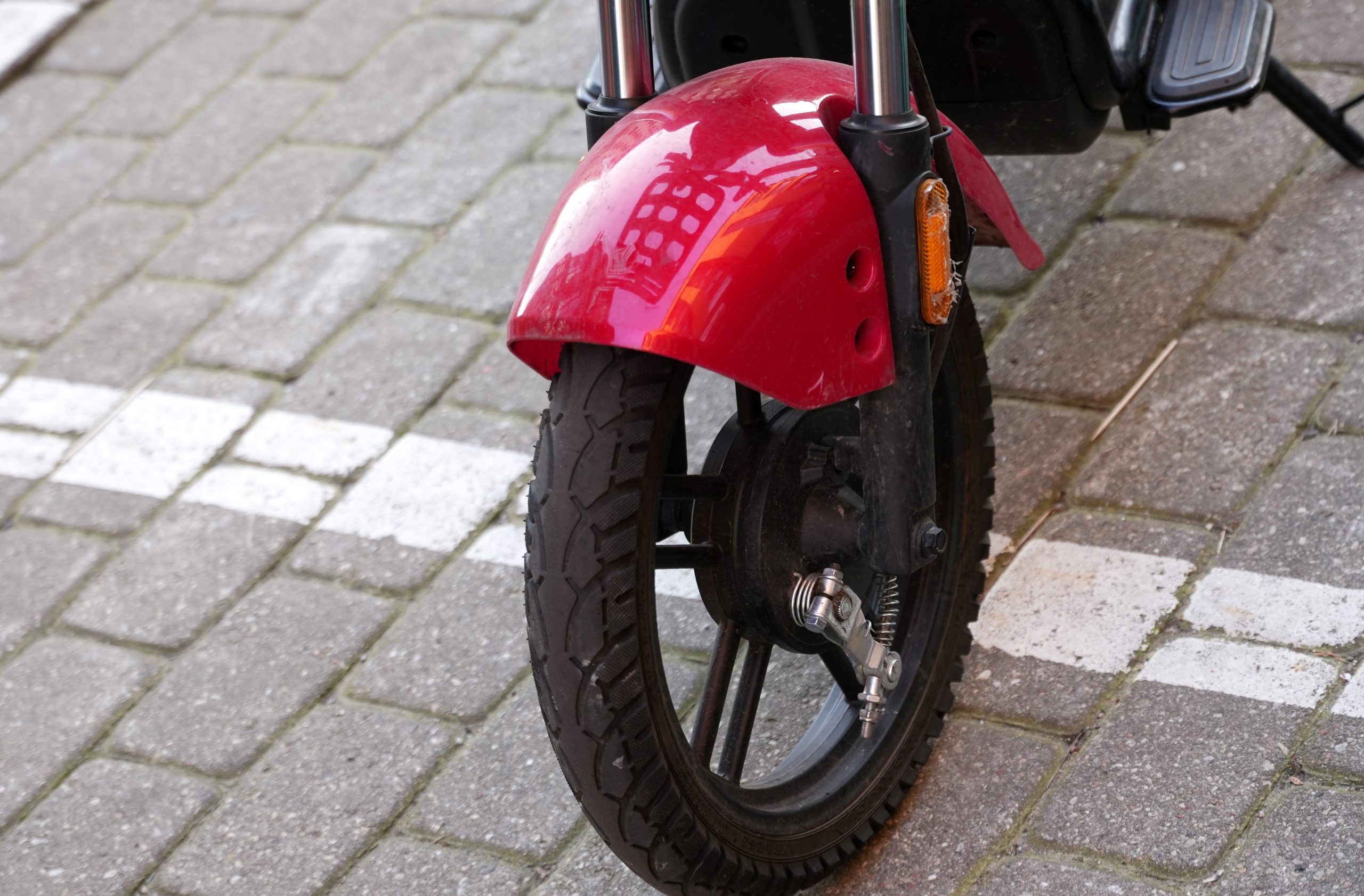 Elektriskā motorollera priekšējais ritenis ar sarkanu spārnu