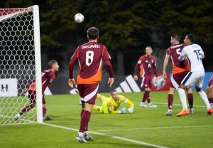 Latvijas futbola izlases spēlētāji aizsargā savus vārtus spēlē pret Anglijas komandu.