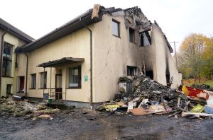 Pirmsskolas izglītības iestādes "Bitīte" korpuss pēc ugunsgrēka, ar masīvu apdegumu uz fasādes un gruvešu kaudzi pie ēkas pamata.