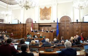 Saeimas sēde ar deputātiem zālē un sēdes vadību priekšplānā