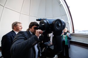 Vīrietis vēro debesis ar jauno teleskopu LU Astronomiskajā tornī.