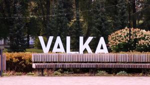 Valkas pilsētas vides objekts ar lieliem burtiem “VALKA” un soliņu pilsētas parkā.