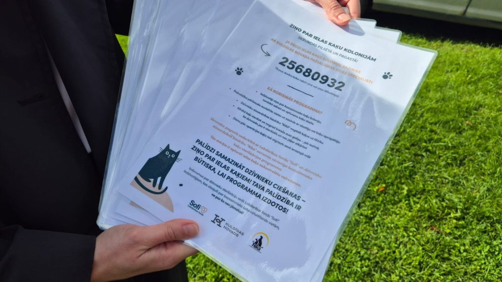 Informatīvais buklets par bezsaimnieku kaķu programmu "Noķer, sterilizē, atlaid" ar tālruņa numuru ziņošanai.