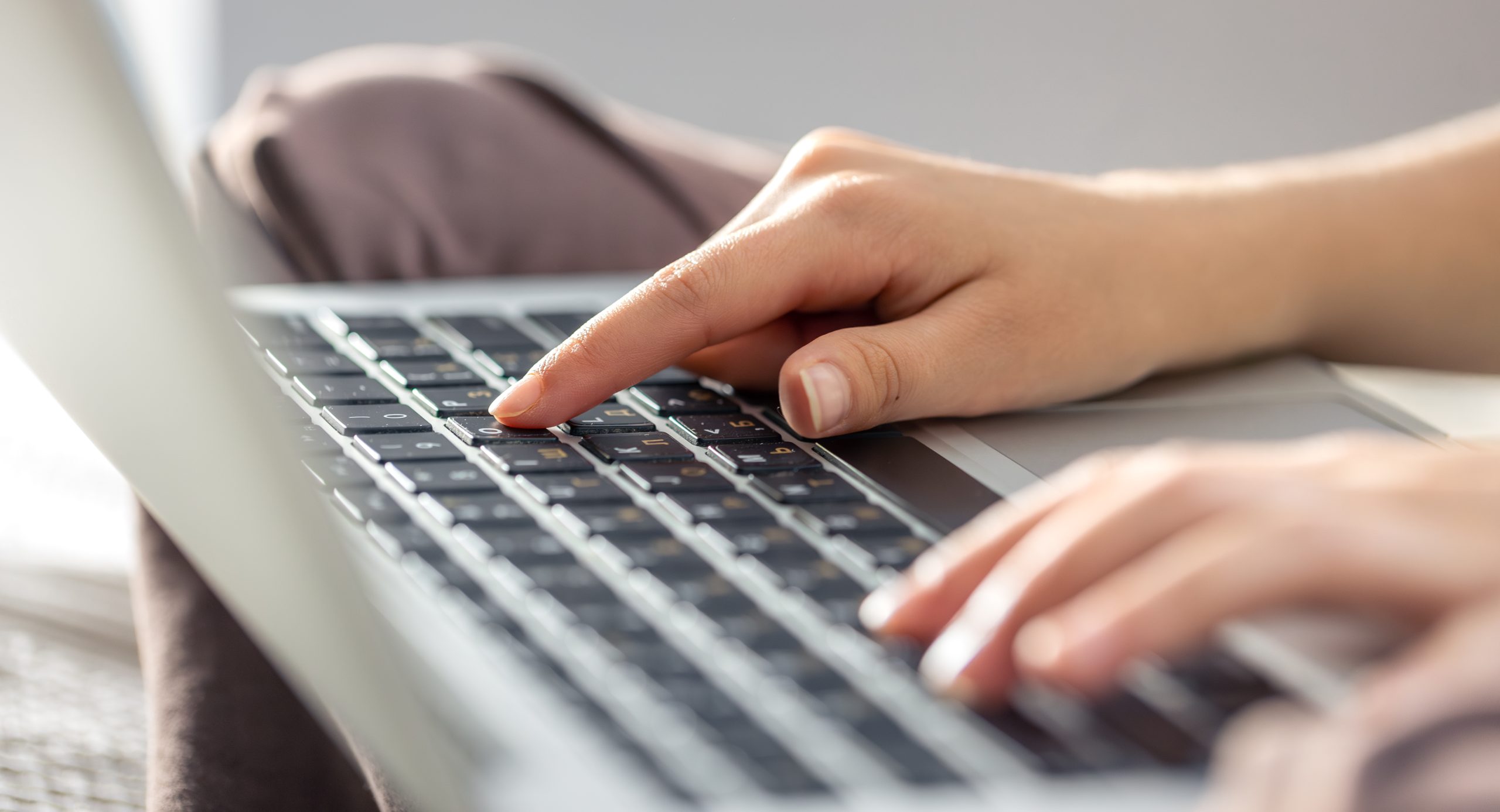 Rokas raksta uz klēpjdatora tastatūras