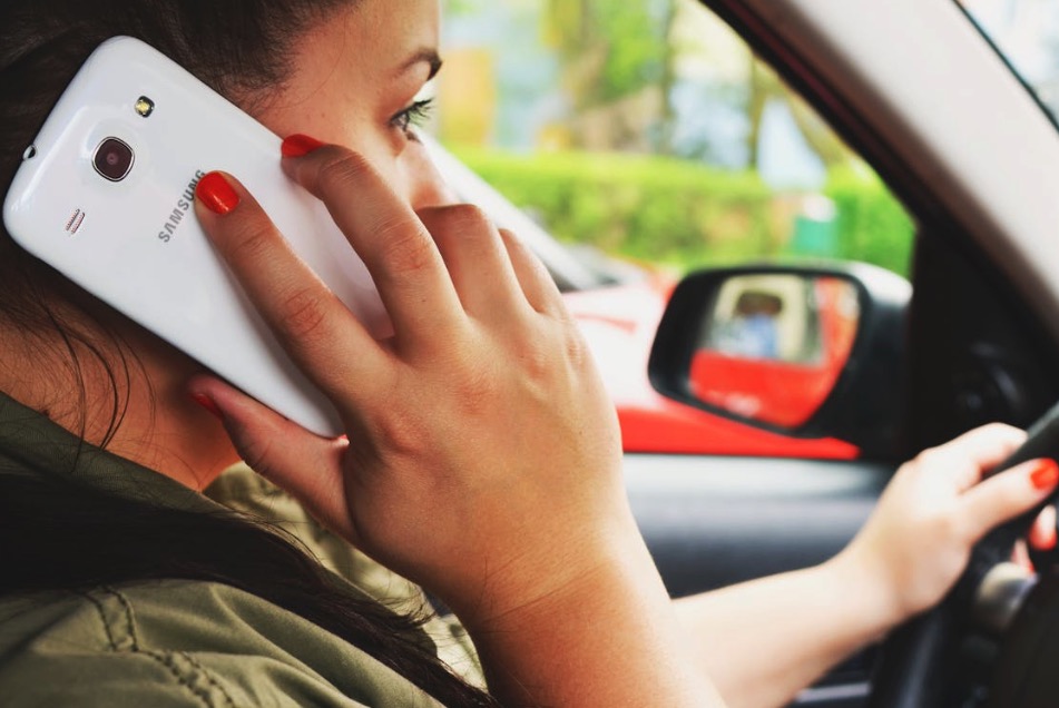 Sieviete runā pa telefonu, vadot automašīnu – uzmanības novēršana pie stūres.