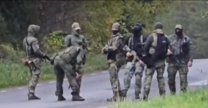 Bruņotu Krievijas robežsargu grupa militārajās formās stāv uz ceļa uz Igaunijas un Krievijas robežas.