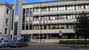 Jelgavas novada pašvaldības galvenā ieeja ar pašvaldības ģerboni uz stikla durvīm.