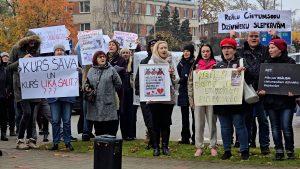 Cilvēki ar plakātiem piedalās piketā, pieprasot sodu par dzīvnieku nogalināšanu.