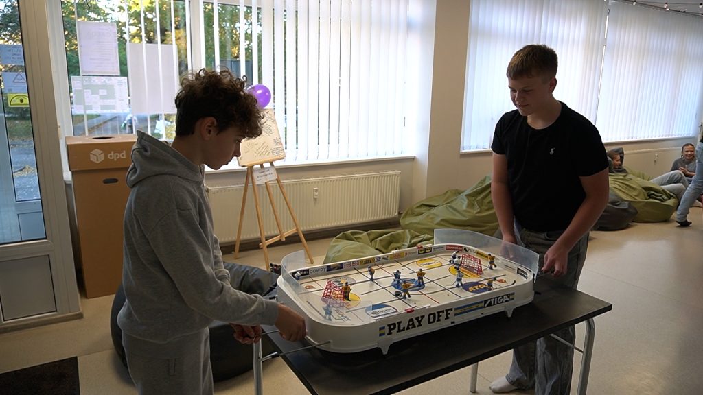 Divi pusaudži spēlē galda hokeju Jauniešu iniciatīvu centrā "Pietura" Jelgavā.