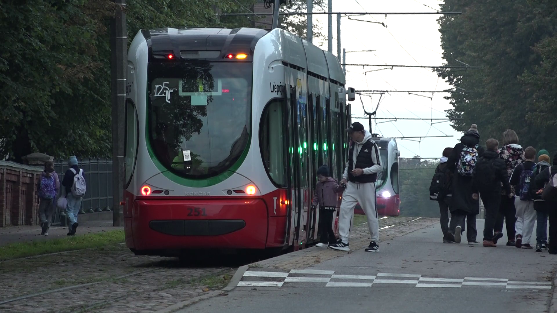 Cilvēki iekāpj tramvajā Liepājā agrā rītā.