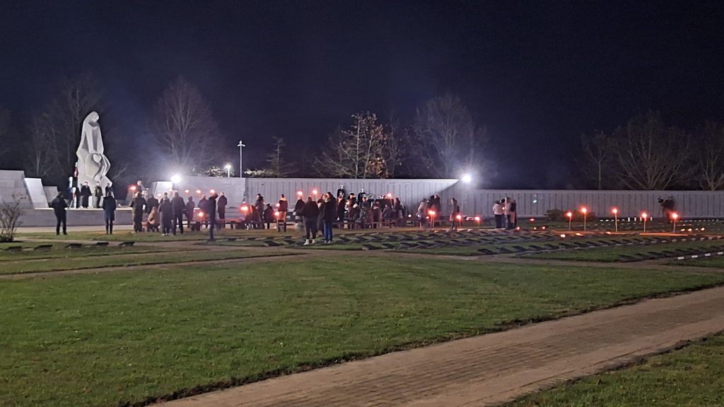 Cilvēki ar degošām lāpām atrodas Lestenes Brāļu kapu teritorijā pie memoriālā pieminekļa naktī.