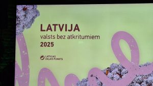 Ekrāns ar uzrakstu "LATVIJA valsts bez atkritumiem 2025" un logotipu "LATVIJAS ZAĻAIS PUNKTS".