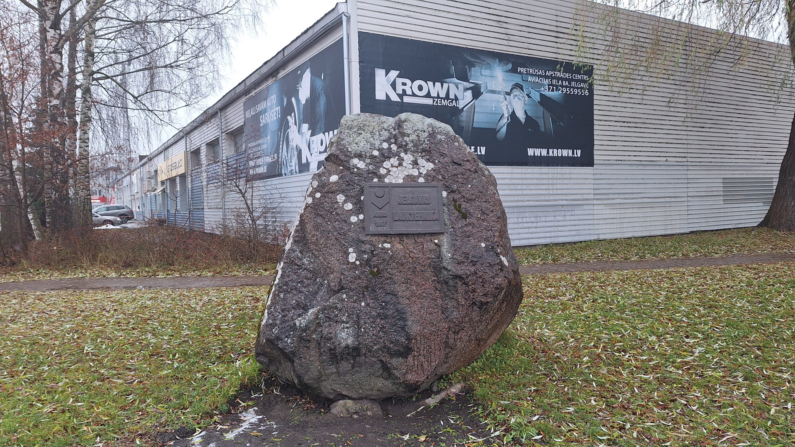 Liels laukakmens ar metāla plāksni un uzrakstu 