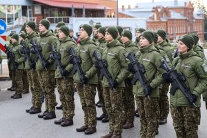 Rēzeknē rindā stāvoši Valsts robežsardzes kadeti kamuflāžas uniformās ar ieročiem (šautenēm) zvēresta došanas ceremonijas laikā.