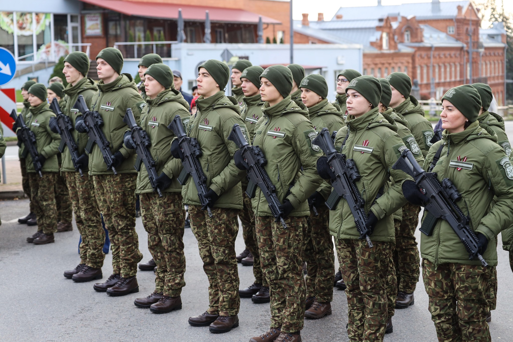 Rēzeknē rindā stāvoši Valsts robežsardzes kadeti kamuflāžas uniformās ar ieročiem (šautenēm) zvēresta došanas ceremonijas laikā.