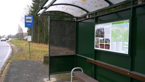 Autobusa pietura ar informatīvo paneli, kurā izvietoti stāsti par vietējo vēsturi un karte.
