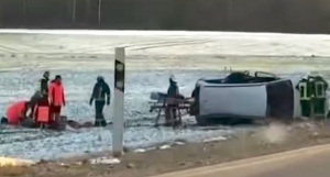 Avārijas vieta Saldus novadā ar apgāzušos automašīnu un glābēju darbu sniegotā laukā.