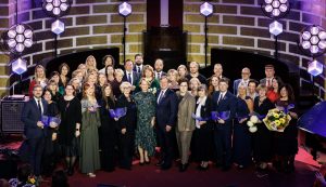 Balvas "Latvijas Gada skolotājs 2025" laureāti un ministri lielajā kopbildē uz skatuves.