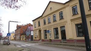 Jaunjelgavas kultūras centra ēka pilsētas centrā, pie ielas ar vēsturiskām ēkām.