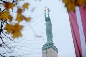 Brīvības piemineklis Rīgā ar zeltītajām zvaigznēm un Latvijas karoga kontūru rudenī