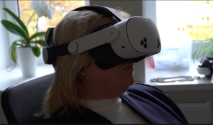 Sieviete izmēģina virtuālās realitātes brilles rehabilitācijas procesā.