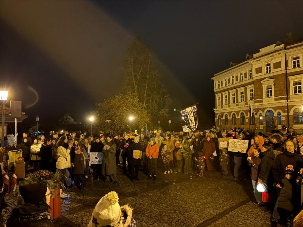 Cilvēki ar plakātiem un lukturīšiem pulcējušies Cēsīs Rožu laukumā pie nelielas ēkas naktī, protestējot pret Stambulas konvencijas denonsēšanu.